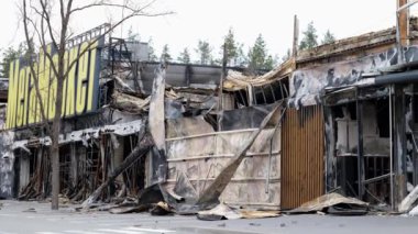 2022 baharında Bucha, Kyiv Oblastı, Ukrayna 'da bombardıman sonrası. Üzerinde Megamarket yazan yanmış bir alışveriş merkezi var. Alışveriş merkezi. Kısmen görünür. Sahne yıkıcı şeyleri resmediyor.