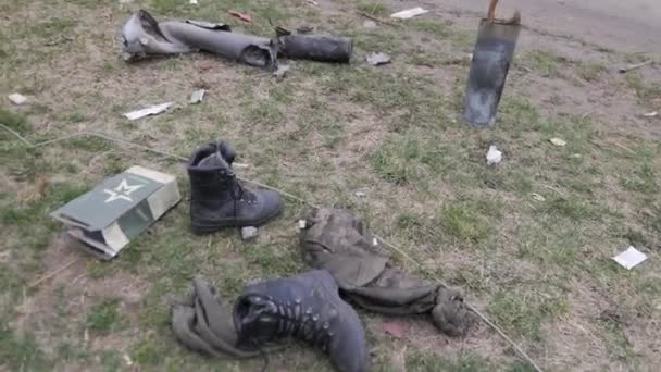 在一幅描述袭击后果的阴郁画面中 照片显示靴子散落在街上的草地上 这种悲惨的景象是战争破坏性影响的有力象征 — 图库视频影像