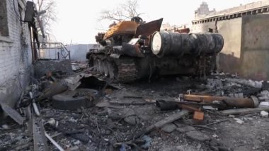 Resim, Ukrayna 'da yıkılan evler ve Kyiv oblast' ın Velyka Dymerka kasabasındaki yanan bir tankın resmedildiği bombalı saldırıların yıkıcı sonuçlarını kaydediyor. Bu sahne akıllara durgunluk veriyor.