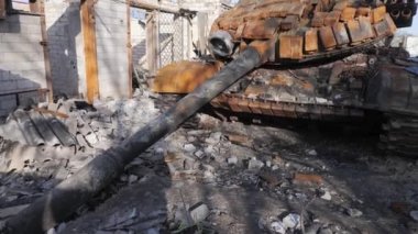 Resim, Ukrayna 'da yıkılan evler ve Kyiv oblast' ın Velyka Dymerka kasabasındaki yanan bir tankın resmedildiği bombalı saldırıların yıkıcı sonuçlarını kaydediyor. Bu sahne akıllara durgunluk veriyor.