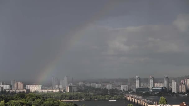 この魅力的なビデオは キエフ上空の雨の後に現れる虹の自然な光景の美しさを伝えます 空に輝く明るい色が輝き 街並みに魔法を加えています このシーンは — ストック動画