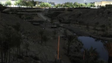 Yeşil ağaçlar ve çalılarla çevrili küçük temiz bir gölet. Ön planda, bir şelale kayaların üzerinde çağlıyor. Bu sakin sahneyi yüksek kaliteli 4K görüntülerle çekin. Akşam için mükemmel..