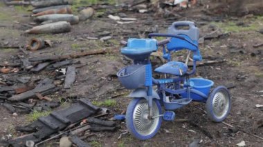 Ukrayna 'da ön planda yapılan savaşta çocuk bisikleti ve mermi yığını. Askeri füze, mermiler. Chernihiv. Görüntü Ukrayna 'daki savaşın acımasız gerçekliğini gösteriyor.