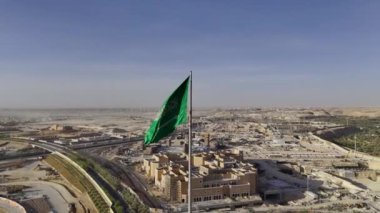 Suudi Arabistan 'ın en büyük ulusal bayrağı. Bu çarpıcı videoda, Suudi Arabistan 'ın en büyük bayrağı açıldı ve görkemli bir şekilde halka açık bir yerde dalgalanıyor. Koyu yeşil arka planı ve cüretkar