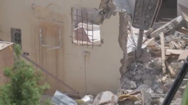 Suudi Arabistan Kazıcı 'daki konut binalarının yıkımı inşaat atıklarını yüklüyor ve taşıyor, işçiler ona yardım ediyor. Bu görüntü, bir yerleşim yerinin yıkıldığı dramatik sahneyi gösteriyor.