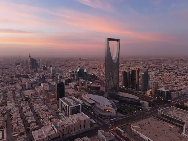 Stock image This drone shot unveils Riyadh, Saudi Arabia, in the vibrant light of day. Sunrise. Kingdom Tower The intricate crossroads of roads weave through the city, a testament to urban planning. The landscape