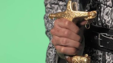 Geleneksel Suudi ayağının üzerinde kromakey. Arap uzun kılıcı - saif. Video, geleneksel Suudi kıyafetlerini kromakey yeşil ekrana karşı gösteriyor. Genellikle dijital ortamda kolaylık için video yapımında kullanılıyor.