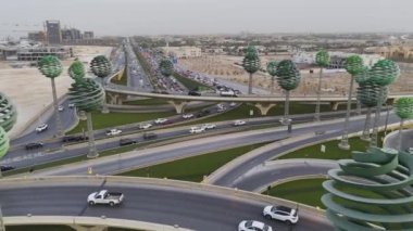 Yoğun otoyolun insansız hava aracı görüntüsü Yeşil Alan Riyad KSA. Bu video, arabaların ve kamyonların parlak güneşin altında yol boyunca koştuğu Suudi Arabistan 'ın Riyad kentindeki işlek bir otoyolu çekiyor. Otoyol...
