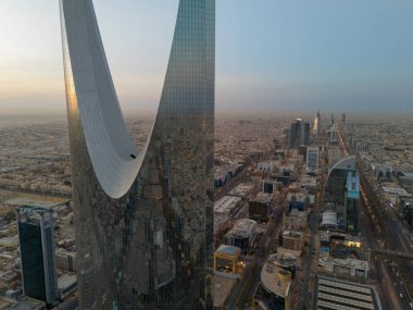 Bu İHA atışı, Suudi Arabistan, Riyad 'ı gün ışığında ortaya çıkarıyor. Gün doğumu. Krallık Kulesi, şehir planlamasının bir kanıtı olarak, şehir boyunca uzanan yolların kesiştiği yer. Manzara