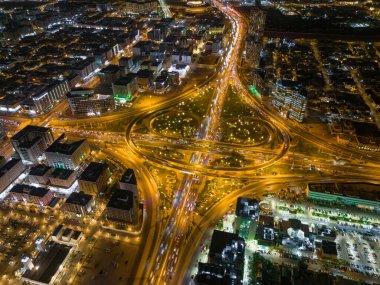 Yol. Yol ayrımı. Riyad. İHA uçuşu. Gün batımı. İyi akşamlar. Bu drone fotoğrafı, akşam ve güneş batarken Suudi Arabistan, Riyad 'ın karışık yol ağını gösteriyor. Çekim bir...