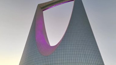 İnsansız uçak zarif bir şekilde Suudi Arabistan, Riyad üzerinde süzülerek görkemli Krallık Kulesi 'ni gün ışığında ele geçirdi. Gün doğumu. Şehir, mimarisinde modernliği yansıtırken, yerin altına yayılır.