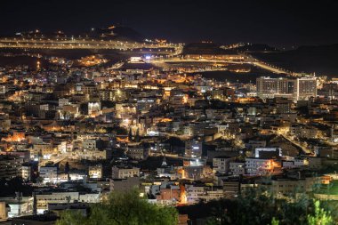 Abha City 'nin göz kamaştırıcı bir silueti var. Abha 'nın, Suudi Arabistan' ın, gece gökyüzünün altında parlayan nefes kesici hava manzarası. Şehrin canlı ışıkları dağlık araziye yayıldı.