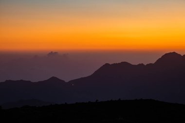 Golden Sunset Over Abha Mountains, Saudi Arabia.A breathtaking view of the sun setting over the mountains of Abha, Saudi Arabia. The sky transitions from deep orange to soft blue, creating a clipart