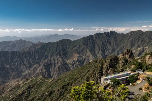 Suudi Arabistan, Abha 'nın nefes kesici dağ manzarası. Suudi Arabistan, Abha 'yı çevreleyen dağların büyüleyici panoramik görüntüsü. Yuvarlanan yeşil tepeler, dolambaçlı yollar ve sisli bulutlar