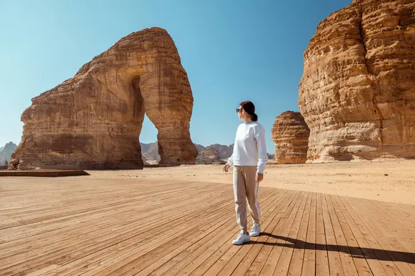 Alula 'da Fil Kayası Keşfeden Kadın, Suudi Arabistan Iconic Desert Landmark. Bir gezgin, Suudi Arabistan 'ın en ünlü jeolojik harikalarından biri olan Alula' daki Görkemli Fil Kayası 'na hayran.