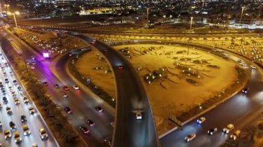 Riyad Şehir Işıkları ve Otobanları Gece Hava Görüntüsü. KAFD. Riyad, Suudi Arabistan 'ın etkileyici bir gece manzarası aydınlanmış otoyolları, modern şehir manzarası ve hareketli şehir yaşamını gözler önüne seriyor.