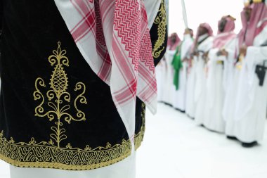 Geleneksel Suudi Arabistan Giyimi Kültür Mirasının Sembolü. Geleneksel Suudi Arabistan giysisinin yakın plan görüntüsü, altın işlemeli, ikonik kırmızı-beyaz