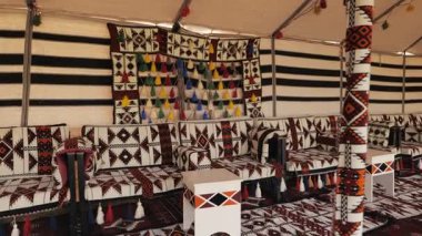Suudi Arabistan 'daki geleneksel bir Bedevi Çadırı' nın iç mekanı. Suudi Arabistan 'da güzel dekore edilmiş geleneksel bir Bedevi çadırı, renkli geometrik desenler, dokuma halılar ve