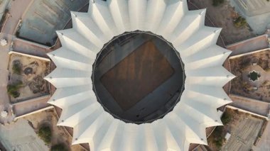 Riyad Stadyumu 'nun gündoğumunun hava görüntüsü. Güneş doğarken Suudi Arabistan 'ın Riyad kentindeki ikonik stadyumu gösteren sakin bir hava manzarası. Yapının eşsiz beyaz, çadırımsı çatısı.