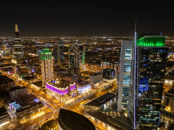 Riyad Skyline 'ın Gece Kenti manzarası. Suudi Arabistan, Riyad 'ın aydınlık siluetini gösteren canlı bir gece-zaman hava görüntüsü. Şehir ışıl ışıl parlıyor, gökdelenler yükseliyor.