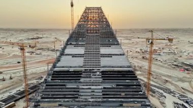 King Salman Park İnşaat. Gün doğumu. Suudi Arabistan 'ın Riyad kentindeki King Salman Parkı' nda devam eden inşaatın etkileyici bir hava görüntüsü. Yüksek vinçler ve devasa çelik bir yapı.
