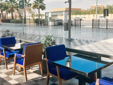 U-Walk Riyad 'da açık hava oturma alanı. Suudi Arabistan, Riyad 'da U-Walk' da şık bir açık hava oturma alanı. Modern mavi sandalyeler ve parlak cam masalar rahat ama zarif bir atmosfer yaratır.