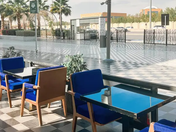 U-Walk Riyad 'da açık hava oturma alanı. Suudi Arabistan, Riyad 'da U-Walk' da şık bir açık hava oturma alanı. Modern mavi sandalyeler ve parlak cam masalar rahat ama zarif bir atmosfer yaratır.