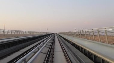 KSA Çölü 'ndeki yüksek hızlı metro rayları. Suudi Arabistan KSA 'nın çöl manzarasından geçen yüksek bir metro rayında pürüzsüz bir yolculuk. Manzara dinamik hareketi ve modern