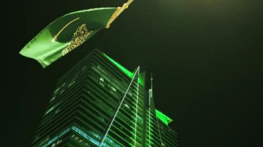 Ulusal Bayram kutlamalarında Suudi Bayrağı Gece Dalgalanıyor. Suudi Arabistan bayrağının yakın çekimleri Ulusal Bayram 'ı simgeleyen yeşil ışıklarla süslenmiş aydınlanmış bir kulenin önünde gururla dalgalanıyor.