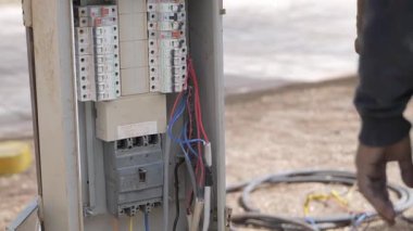 Elektrik Güç Dağıtım Kutusu. Açık hava elektrik panelinin açıkta kalan kabloları ve devre kesicileri olan yakın görüntüsü. Video, güç yönetimi için kullanılan teknik altyapıyı yakalıyor, muhtemelen