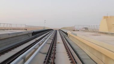 KSA Çölü 'ndeki yüksek hızlı metro rayları. Suudi Arabistan KSA 'nın çöl manzarasından geçen yüksek bir metro rayında pürüzsüz bir yolculuk. Manzara dinamik hareketi ve modern