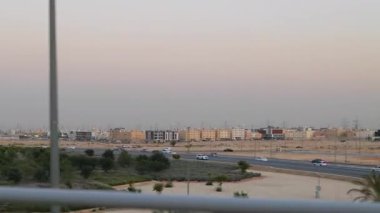 Sunset KSA 'daki Riyad Metro' dan görüntü. Suudi Arabistan 'da gün batımında yakalanan Riyad Metro' nun penceresinden sakin bir manzara ve şehrin ufuk çizgisi. Gökyüzünün yumuşak renkleri harmanlanır
