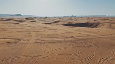 Suudi kum tepelerinin Sonsuz Çöl Ucu İHA videosu. Suudi Arabistan 'daki uçsuz bucaksız altın kum tepelerini gösteren çarpıcı bir insansız hava aracı videosu. Havadaki görüntüler rüzgâr şeklindeki büyüleyici desenleri ortaya çıkarıyor.
