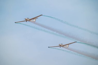 Suudi gökyüzü üzerinde senkronize planörler. İki gösterişli planör Suudi Arabistan Krallığı 'ndaki bir hava gösterisinde kusursuz bir senkronize uçuş gerçekleştiriyor ve gökyüzünde zarif izler bırakıyor. Huzurlu ama