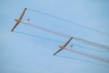 Suudi gökyüzü üzerinde senkronize planörler. İki gösterişli planör Suudi Arabistan Krallığı 'ndaki bir hava gösterisinde kusursuz bir senkronize uçuş gerçekleştiriyor ve gökyüzünde zarif izler bırakıyor. Huzurlu ama