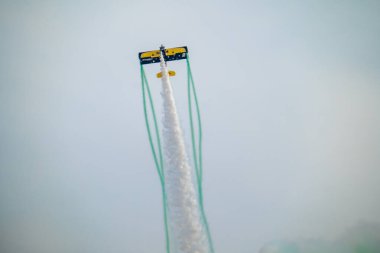 Wingwalker KSA Hava Gösterisi 'nde Suudi Çölü Havacılık Daring' in üstünde uçuyor. Korkusuz bir kanat yürüyüşçüsü, bir havacılık gösterisi sırasında çölde süzülen klasik sarı bir çift kanatlı uçağın tepesinde nefes kesici bir gösteri sergiliyor.