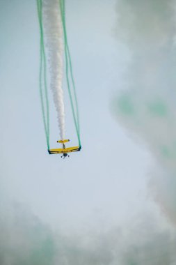 Wingwalker KSA Hava Gösterisi 'nde Suudi Çölü Havacılık Daring' in üstünde uçuyor. Korkusuz bir kanat yürüyüşçüsü, bir havacılık gösterisi sırasında çölde süzülen klasik sarı bir çift kanatlı uçağın tepesinde nefes kesici bir gösteri sergiliyor.