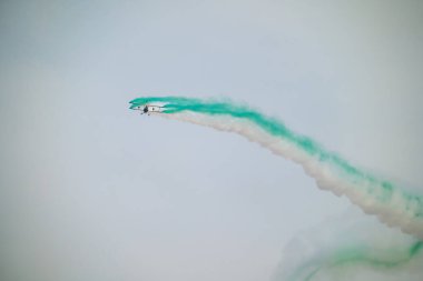 Wingwalker KSA Hava Gösterisi 'nde Suudi Çölü Havacılık Daring' in üstünde uçuyor. Korkusuz bir kanat yürüyüşçüsü, bir havacılık gösterisi sırasında çölde süzülen klasik sarı bir çift kanatlı uçağın tepesinde nefes kesici bir gösteri sergiliyor.