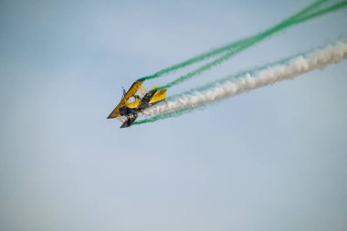 Wingwalker KSA Hava Gösterisi 'nde Suudi Çölü Havacılık Daring' in üstünde uçuyor. Korkusuz bir kanat yürüyüşçüsü, bir havacılık gösterisi sırasında çölde süzülen klasik sarı bir çift kanatlı uçağın tepesinde nefes kesici bir gösteri sergiliyor.