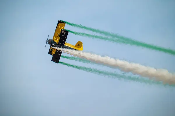 Wingwalker KSA Hava Gösterisi 'nde Suudi Çölü Havacılık Daring' in üstünde uçuyor. Korkusuz bir kanat yürüyüşçüsü, bir havacılık gösterisi sırasında çölde süzülen klasik sarı bir çift kanatlı uçağın tepesinde nefes kesici bir gösteri sergiliyor.