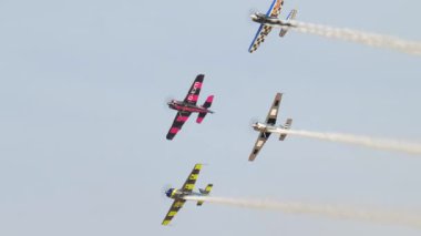 Aerobatik uçaklar Suudi Arabistan 'daki bir havacılık fuarında gösteri yapıyor. Renkli akrobatik uçaklar Suudi Arabistan 'daki bir havacılık gösterisi sırasında senkronize dublörlük yapıyor. Görüntü havada manevra yapıyor.