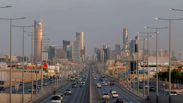 Modern Riyad Skyline ve Busy Highway Suudi Arabistan. Ufuk çizgisinde modern gökdelenlerle Riyad 'ın gökdelenlerinin göz kamaştırıcı gündüz manzarası. Kalabalık otoyol şehir ritmini yakalıyor.