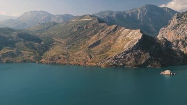 Türkiye 'nin Dağ Kıyıları Hava Manzarası. Kayalık uçurumların derin mavi sularla buluştuğu dramatik dağ kıyılarının çarpıcı klibi. Huzurlu bir sahne, saf güzellikleri gösteriyor.