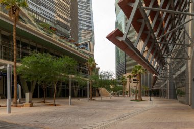 Modern Ofis Binası ve Bahçe Bahçesi KAFD, Riyad, Suudi Arabistan. Yansıtıcı cam cepheleri ve yeşil ağaçlarla süslenmiş bahçeli modern bir ofis manzarası.