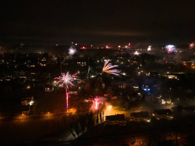 Starnberg 'de Yeni Yıl Havai Fişekleri, Almanya Drone View. Starnberg, Almanya 'da yeni yıl havai fişeklerinin insansız hava aracı fotoğrafı. Renkli havai fişekler şehrin üstündeki gökyüzünü aydınlatıyor, evleri gösteriyor.