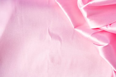 Lüks pastel pembe kumaşın, katlanmış tekstil veya sıvı dalganın ya da dalgalı ipek kumaşın soyut arkaplanı