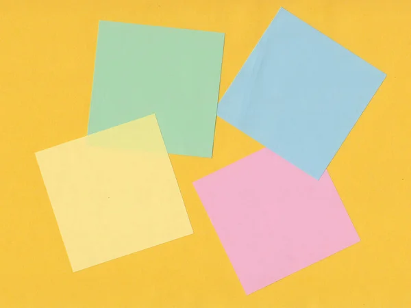 Colorful sticky memo pads on yellow background