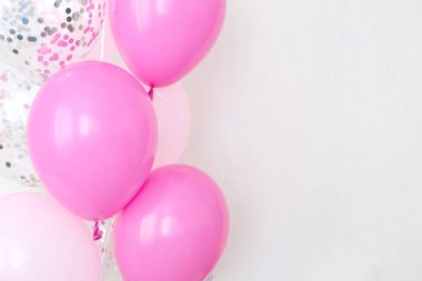 Bir demet pembe ve şeffaf hava balonu gümüş konfetili, metin için kopya alanı, kızlar için yumuşak pastel renkler