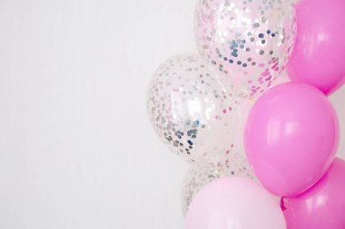 Bir demet pembe ve şeffaf hava balonu gümüş konfetili, metin için kopya alanı, kızlar için yumuşak pastel renkler