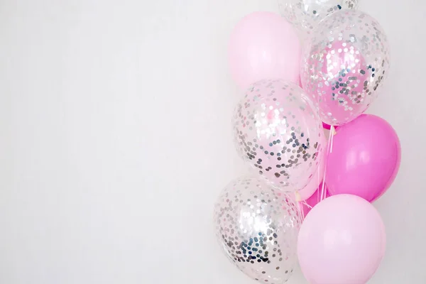 stock image A bundle of pink and transparent air balloons with silver confetti, copy space for your text, tender pastel colors for a girlish party